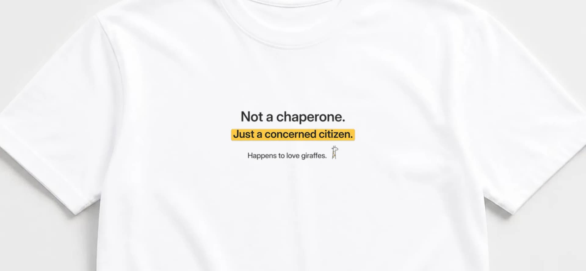 Close-up of white tee with "Not a chaperone." in charcoal, "Just a concerned citizen." on a sunny yellow highlight and a tiny giraffe