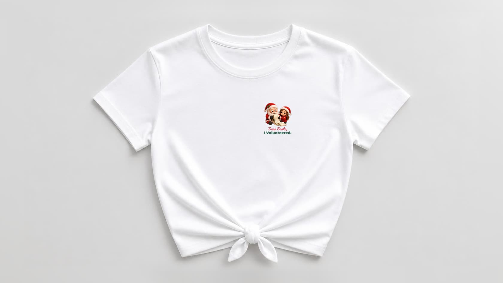 Front of a white knotted women's shirt with a small left-chest print of a plush Santa reading a long list beside a smug plush room mom, above "Dear Santa," in red script and "I Volunteered." in bold green